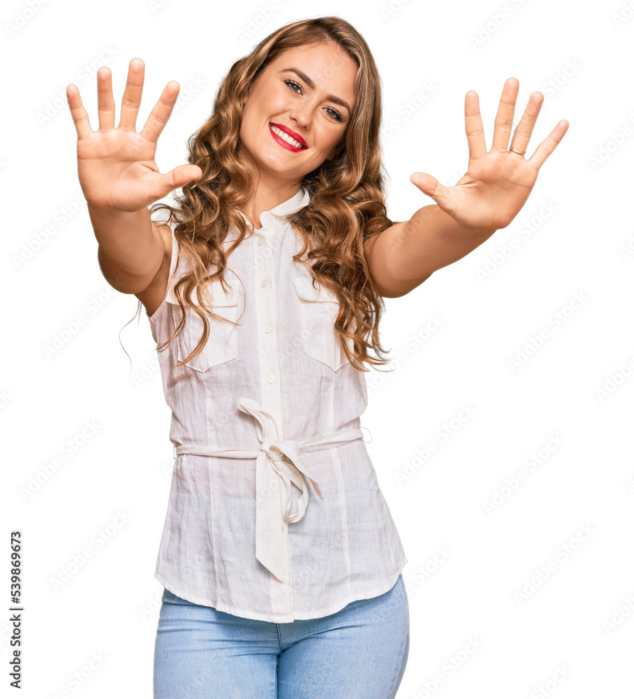 Young blonde girl wearing casual clothes showing and pointing up with fingers number ten while smiling confident and happy.