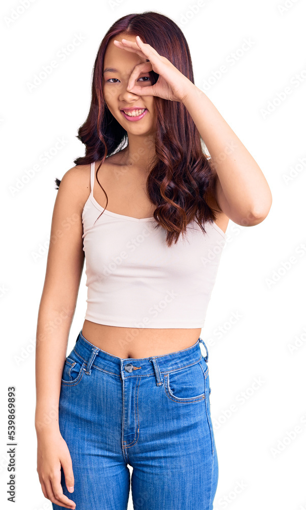 Young beautiful chinese girl wearing casual clothes doing ok gesture with hand smiling, eye looking through fingers with happy face. Young beautiful chinese girl wearing casual clothes doing ok gesture with hand smiling, eye looking through fingers with happy face.