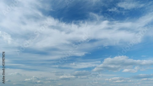 Flying moving white clouds in a blue sky. Blue sky background with many layers tiny clouds. Timelapse.