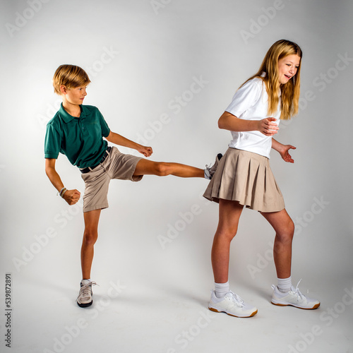 Brother and Sister Playing Fighting in School Uniforms