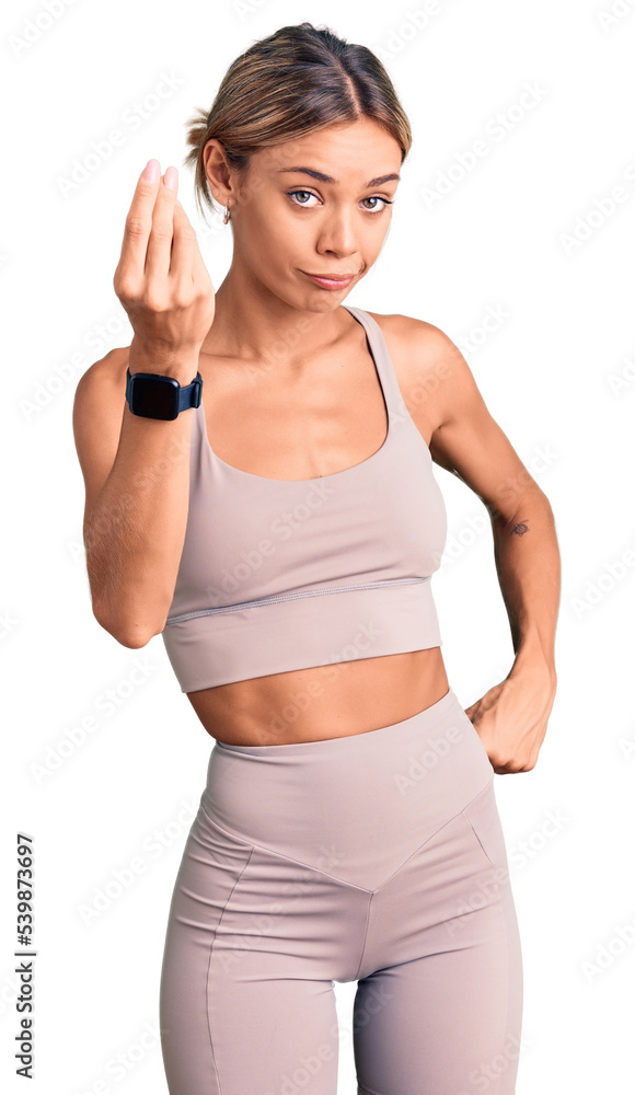 Beautiful caucasian woman wearing sportswear doing italian gesture with hand and fingers confident expression Beautiful caucasian woman wearing sportswear doing italian gesture with hand and fingers confident expression