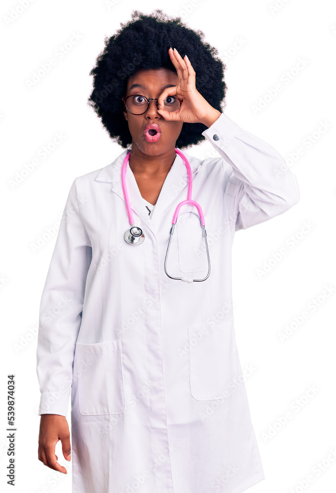 Young african american woman wearing doctor coat and stethoscope doing ok gesture shocked with surprised face, eye looking through fingers. unbelieving expression. Young african american woman wearing doctor coat and stethoscope doing ok gesture shocked with surprised face, eye looking through fingers. unbelieving expression.