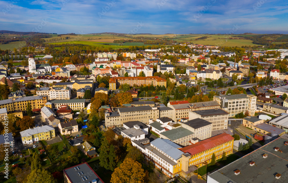Panoramic aerial view of autumn landscape of Czech town of Krnov with white building of St. Martin church and Town hall on main square on sunny day, Moravian-Silesian Region..