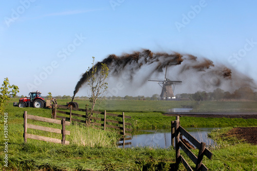 Spreading a mixture of water and fertilized particles onto farmland photo