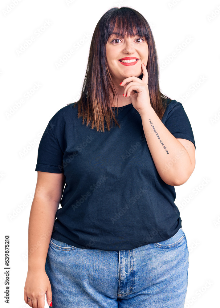 Young plus size woman wearing casual clothes looking confident at the camera with smile with crossed arms and hand raised on chin. thinking positive. Young plus size woman wearing casual clothes looking confident at the camera with smile with crossed arms and hand raised on chin. thinking positive.