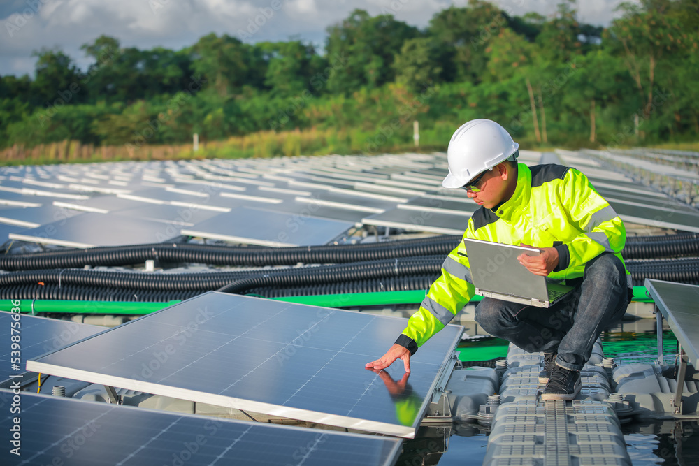 Portrait of professional man engineer working checking the panels at solar energy on buoy floating. Power plant with water, renewable energy source. Eco technology for electric power in industry. Portrait of professional man engineer working checking the panels at solar energy on buoy floating. Power plant with water, renewable energy source. Eco technology for electric power in industry.