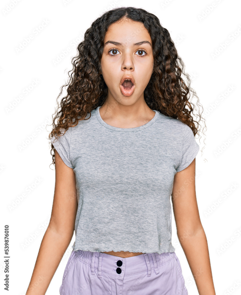 Teenager hispanic girl wearing casual clothes scared and amazed with open mouth for surprise, disbelief face Teenager hispanic girl wearing casual clothes scared and amazed with open mouth for surprise, disbelief face