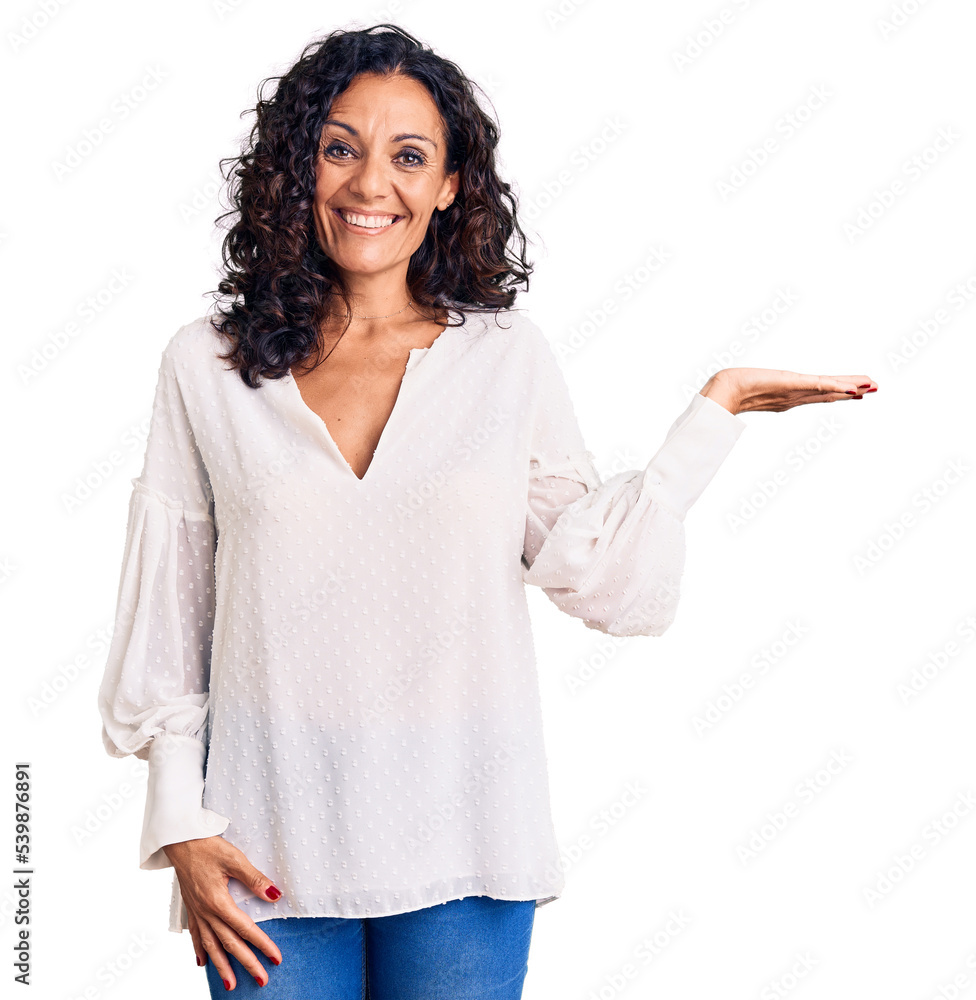 Middle age beautiful woman wearing casual sweater smiling cheerful presenting and pointing with palm of hand looking at the camera. Middle age beautiful woman wearing casual sweater smiling cheerful presenting and pointing with palm of hand looking at the camera.