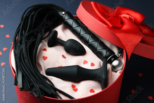 Gift box with different sex toy on dark blue background