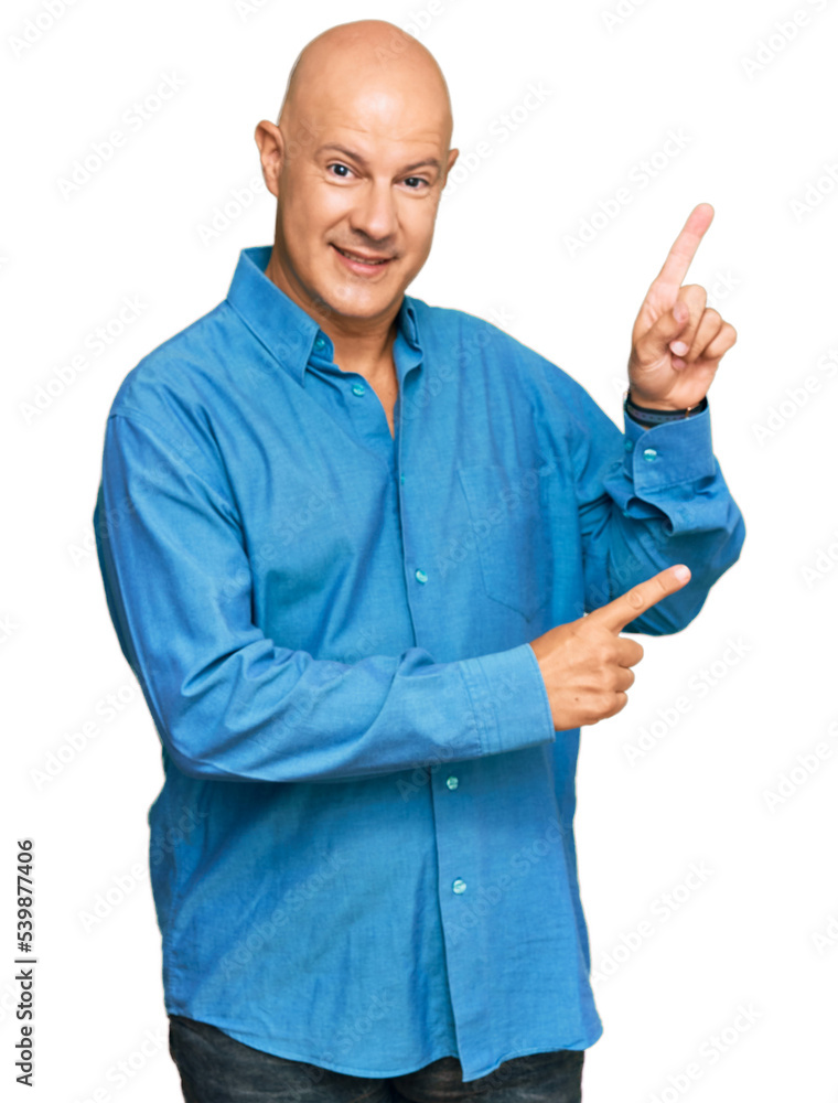 Middle age bald man wearing casual clothes smiling and looking at the camera pointing with two hands and fingers to the side. Middle age bald man wearing casual clothes smiling and looking at the camera pointing with two hands and fingers to the side.