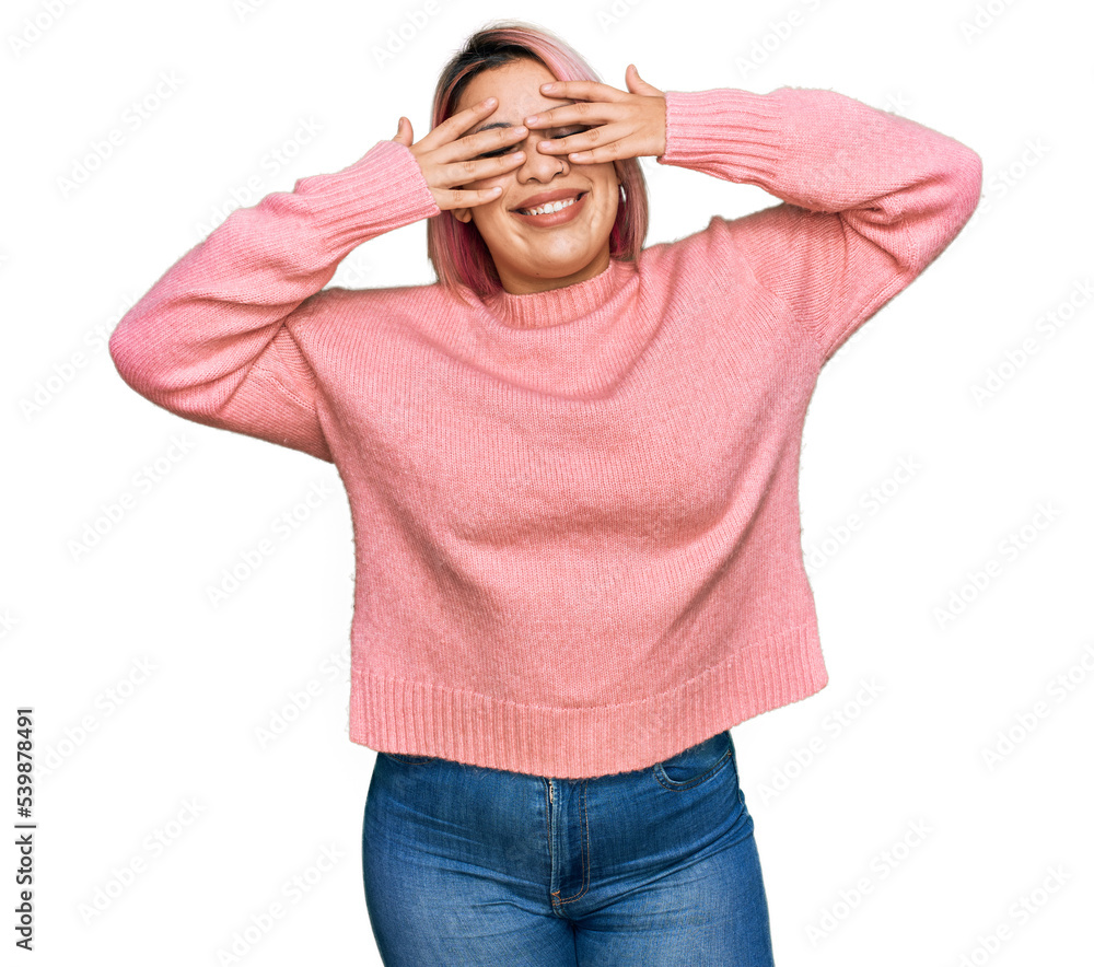 Hispanic woman with pink hair wearing casual winter sweater covering eyes with hands smiling cheerful and funny. blind concept. Hispanic woman with pink hair wearing casual winter sweater covering eyes with hands smiling cheerful and funny. blind concept.