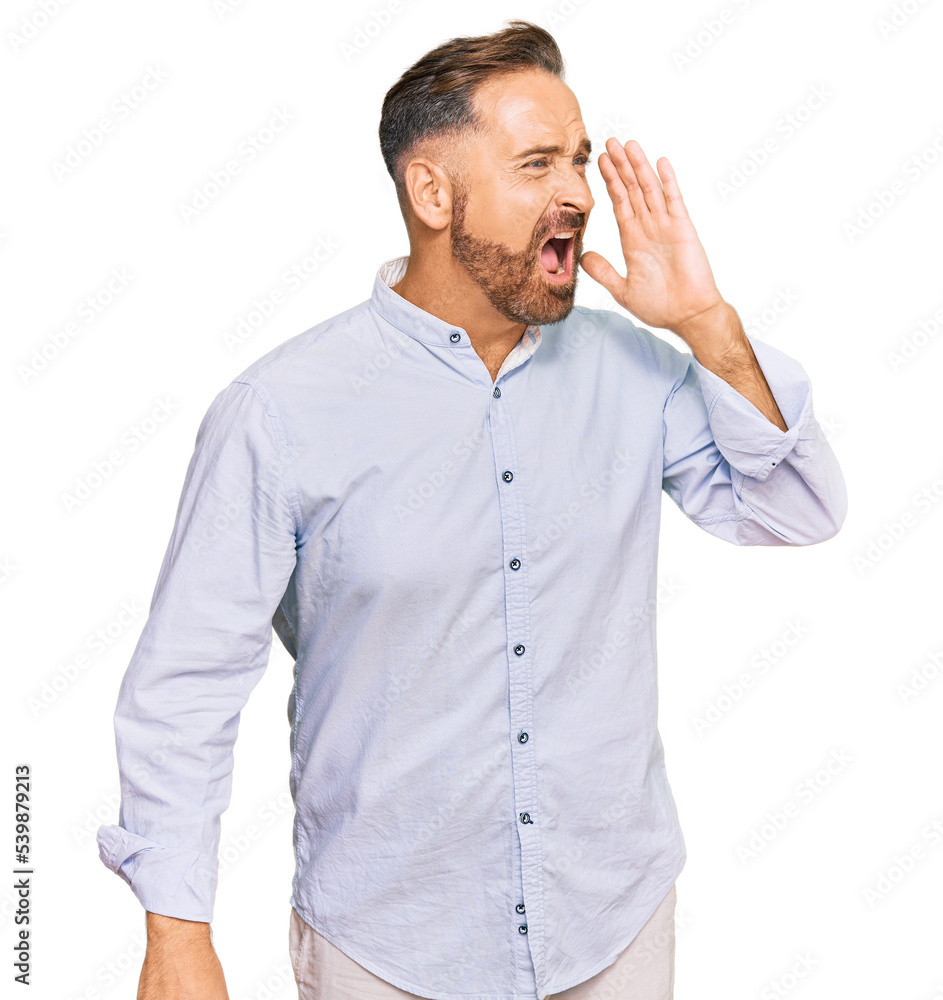 Handsome middle age man wearing business shirt shouting and screaming loud to side with hand on mouth. communication concept. Handsome middle age man wearing business shirt shouting and screaming loud to side with hand on mouth. communication concept.