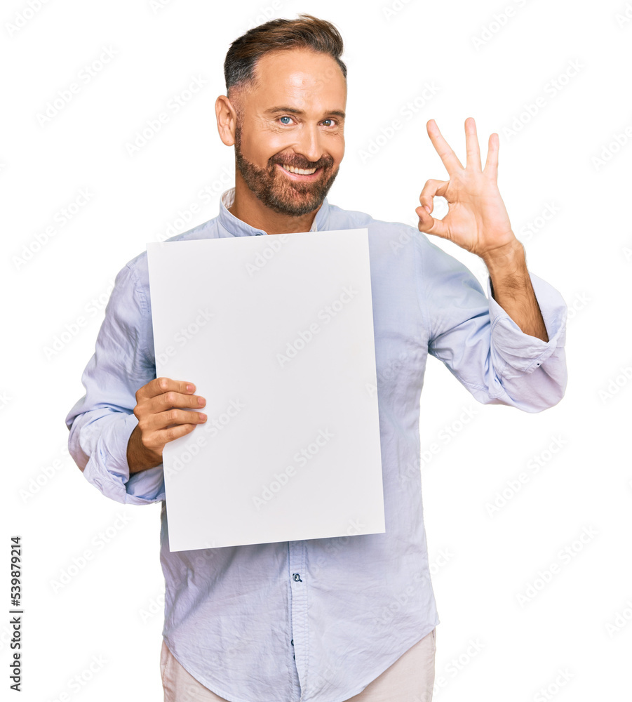 Handsome middle age man holding blank empty banner doing ok sign with fingers, smiling friendly gesturing excellent symbol Handsome middle age man holding blank empty banner doing ok sign with fingers, smiling friendly gesturing excellent symbol