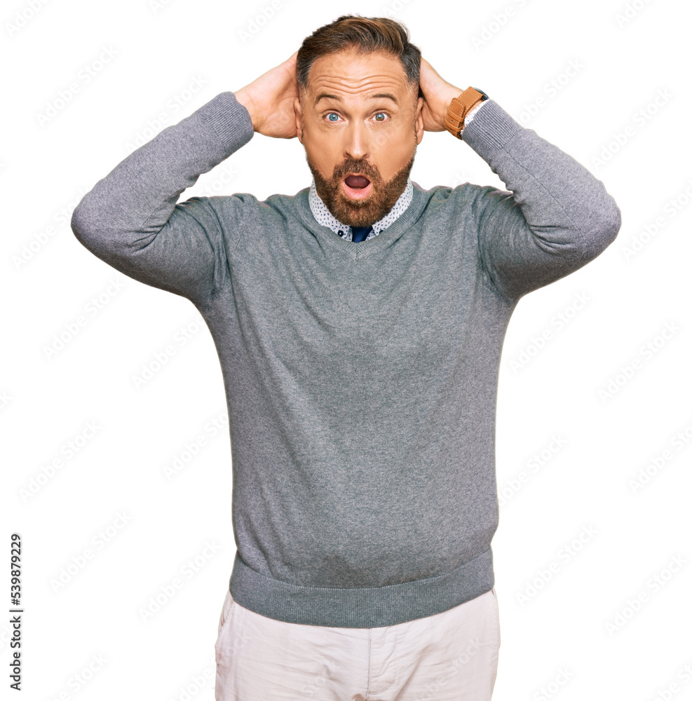 Handsome middle age man wearing business clothes crazy and scared with hands on head, afraid and surprised of shock with open mouth Handsome middle age man wearing business clothes crazy and scared with hands on head, afraid and surprised of shock with open mouth