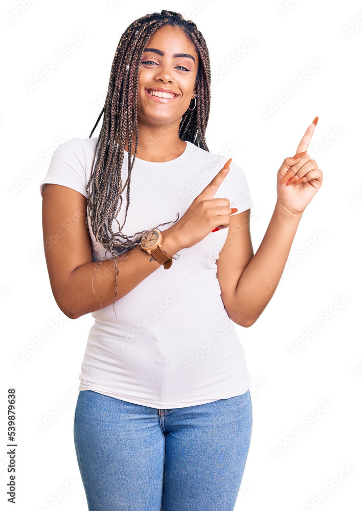 Young african american woman with braids wearing casual clothes smiling and looking at the camera pointing with two hands and fingers to the side. Young african american woman with braids wearing casual clothes smiling and looking at the camera pointing with two hands and fingers to the side.