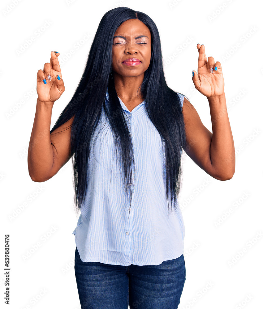 Young african american woman wearing casual clothes gesturing finger crossed smiling with hope and eyes closed. luck and superstitious concept. Young african american woman wearing casual clothes gesturing finger crossed smiling with hope and eyes closed. luck and superstitious concept.