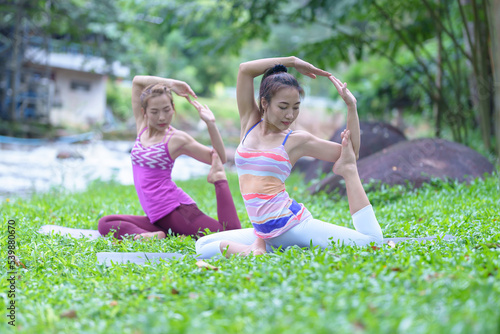 A beautiful young woman group of adults attending a yoga class outside the park., peace and relaxation, woman's happiness