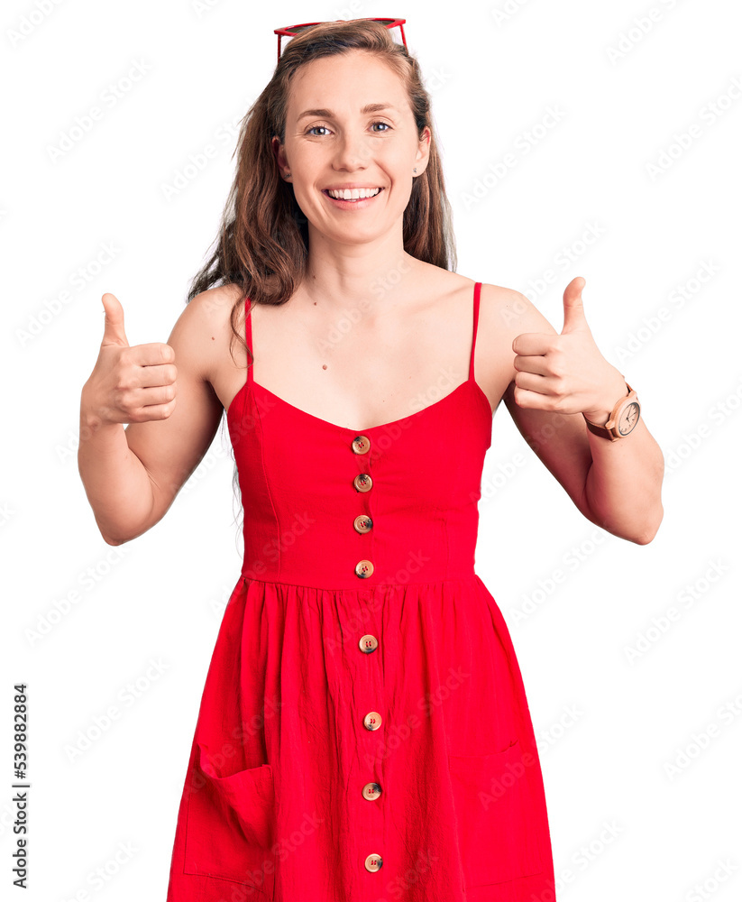 Young beautiful blonde woman wearing casual dress success sign doing positive gesture with hand, thumbs up smiling and happy. cheerful expression and winner gesture. Young beautiful blonde woman wearing casual dress success sign doing positive gesture with hand, thumbs up smiling and happy. cheerful expression and winner gesture.