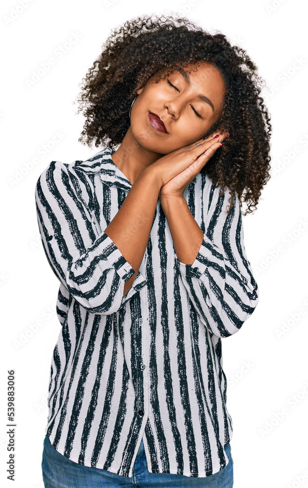 Young african american girl wearing casual clothes sleeping tired dreaming and posing with hands together while smiling with closed eyes. Young african american girl wearing casual clothes sleeping tired dreaming and posing with hands together while smiling with closed eyes.