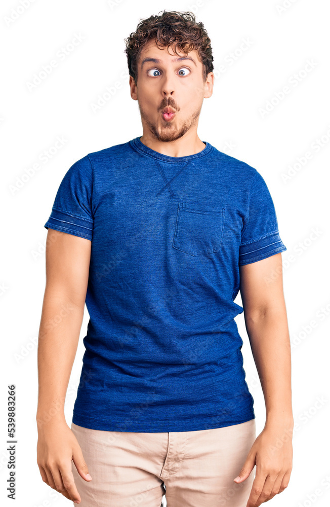Young handsome man with curly hair wearing casual clothes making fish face with lips, crazy and comical gesture. funny expression. Young handsome man with curly hair wearing casual clothes making fish face with lips, crazy and comical gesture. funny expression.