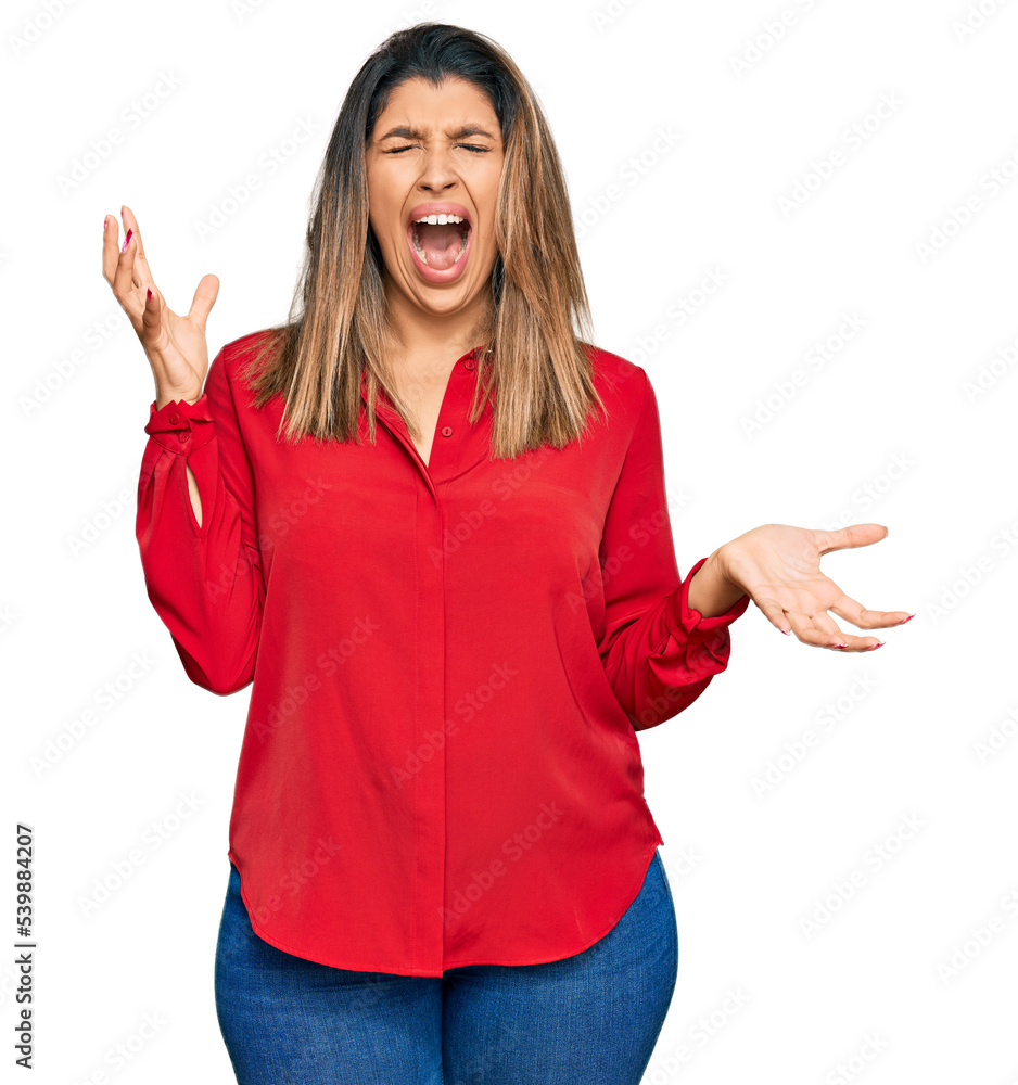 Beautiful brunette woman wearing casual clothes crazy and mad shouting and yelling with aggressive expression and arms raised. frustration concept. Beautiful brunette woman wearing casual clothes crazy and mad shouting and yelling with aggressive expression and arms raised. frustration concept.