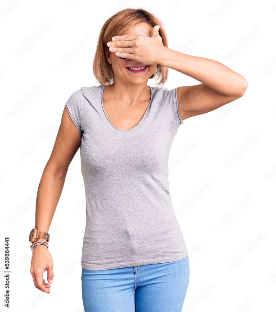 Young blonde woman wearing casual clothes smiling and laughing with hand on face covering eyes for surprise. blind concept. Young blonde woman wearing casual clothes smiling and laughing with hand on face covering eyes for surprise. blind concept.