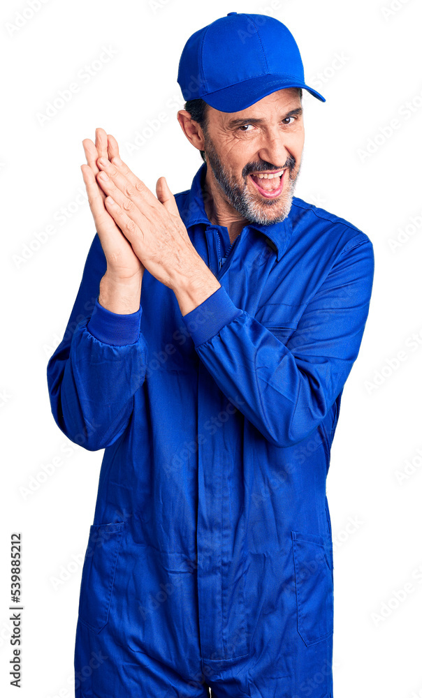 Middle age handsome man wearing mechanic uniform clapping and applauding happy and joyful, smiling proud hands together