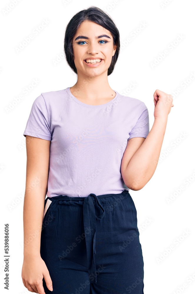 Obraz premium Brunette teenager girl wearing casual clothes smiling with happy face looking and pointing to the side with thumb up.
