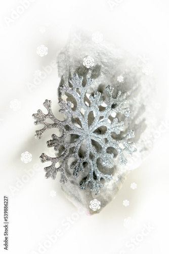 Minimal Christmas composition. Natural marble stand for presentation with silver glitter snowflake.