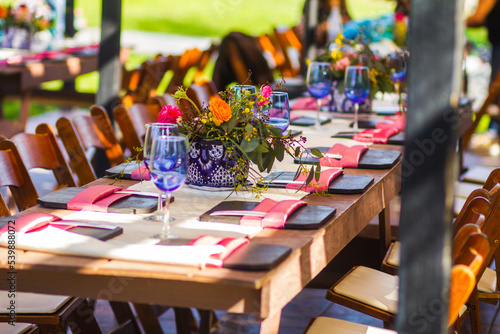 Country set table decoration with colorful flowers in a sunny day at park