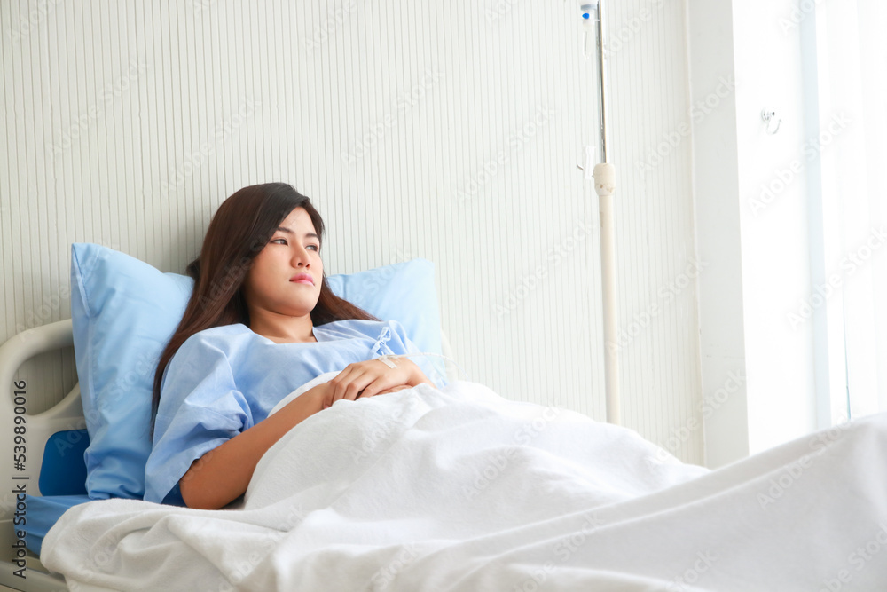 Asian female patient stressed and worried Lie on the bed in the patient room. The concept of health insurance. Hospital medical services Asian female patient stressed and worried Lie on the bed in the patient room. The concept of health insurance. Hospital medical services