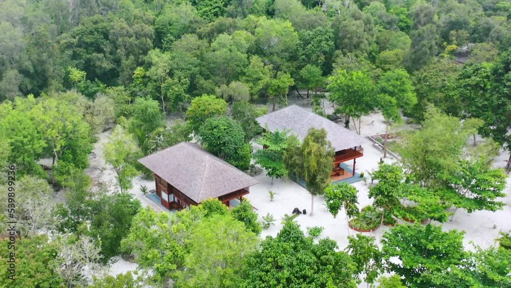 aerial of private homes on Leebong Island in Belitung Indonesia surrounded by dense green forest aerial of private homes on Leebong Island in Belitung Indonesia surrounded by dense green forest