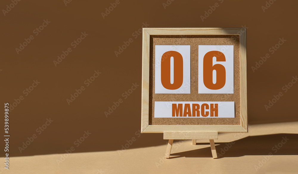 March 6th. Day 6 of month, Calendar date. Cork board, easel in sunlight on desktop. Close-up, brown background. Spring month, day of year concept March 6th. Day 6 of month, Calendar date. Cork board, easel in sunlight on desktop. Close-up, brown background. Spring month, day of year concept