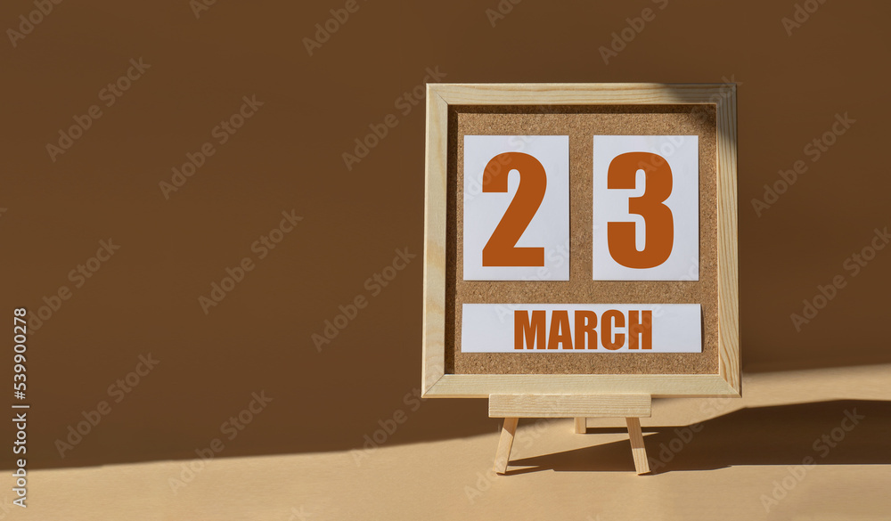 March 23th. Day 23 of month, Calendar date. Cork board, easel in sunlight on desktop. Close-up, brown background. Spring month, day of year concept March 23th. Day 23 of month, Calendar date. Cork board, easel in sunlight on desktop. Close-up, brown background. Spring month, day of year concept