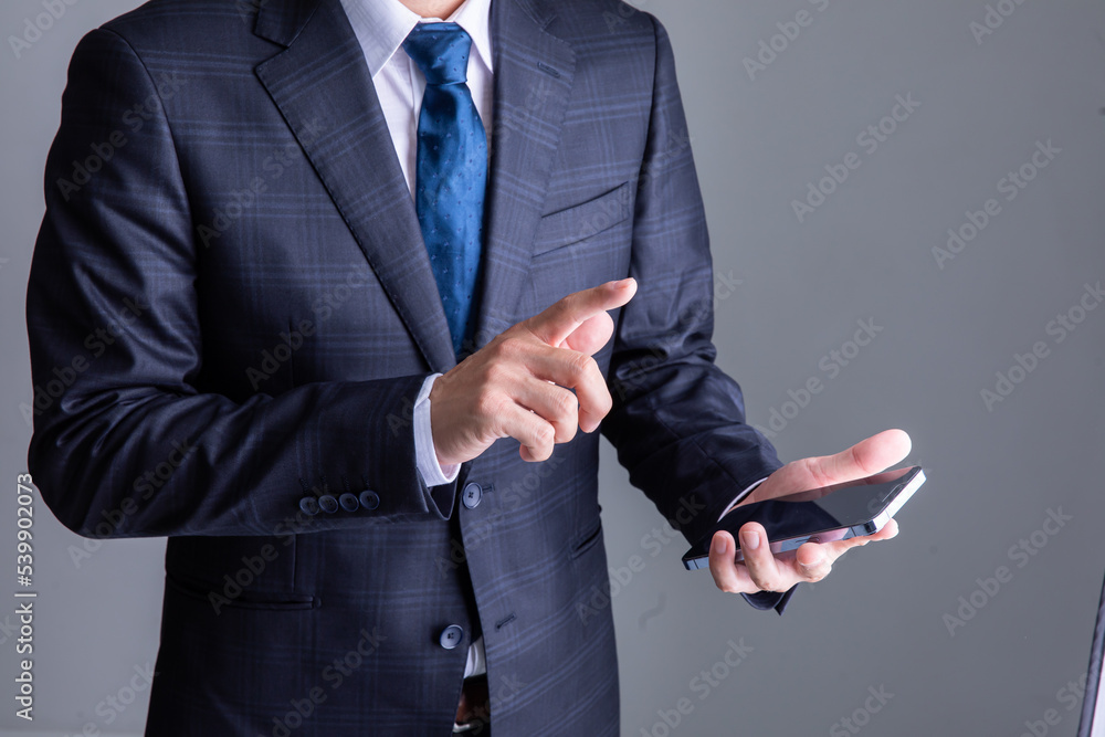 携帯電話を操作するスーツを着た男性　Business	