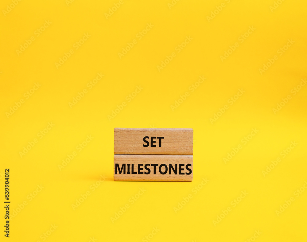 Set milestones symbol. Concept word Set milestones on wooden blocks. Beautiful yellow background. Business and Set milestones concept. Copy space Set milestones symbol. Concept word Set milestones on wooden blocks. Beautiful yellow background. Business and Set milestones concept. Copy space