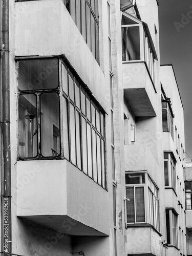 BW facade of avant-garde minimalist house with balconies. Detailed picture of exterior urban architecture. Element of constructivism. Kuzbassugol combine house, Novosibirsk, Gordeev. Vertical photo