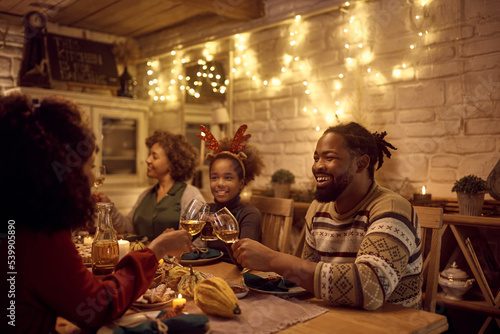 Happy black family toasting during Thanksgiving dinner at dining table.