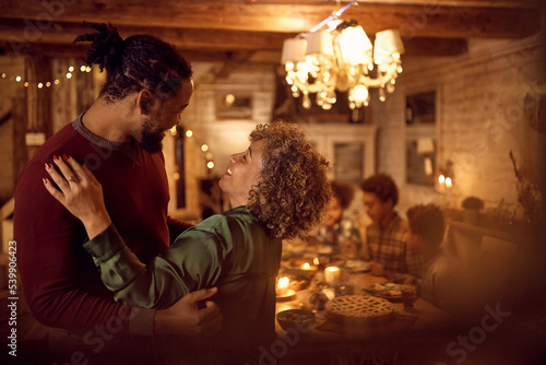 Cheerful black woman and her adult son have fun during family dinner on Thanksgiving.