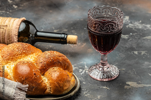 Shabbat Shalom challah bread, shabbat wine on a dark background, place for text, top view photo