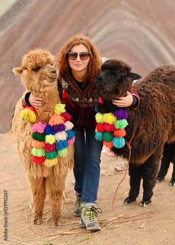 Young red haired girl with two cute alpacas at Vinicunca Rainbow Mountain, Peru photo