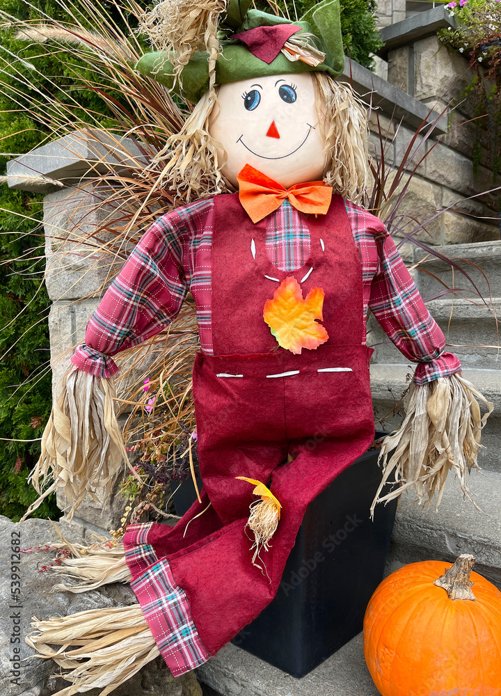 Autumn and Halloween decorative doll with pumpkin in front of the house, Canada