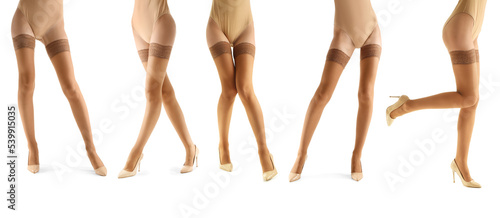Many legs of beautiful young women in beige stockings isolated on white