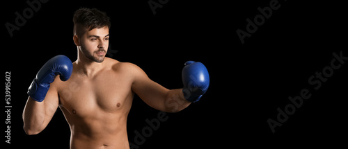 Young muscled boxer on dark background with space for text © Pixel-Shot