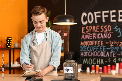 Handsome barista with noteb...