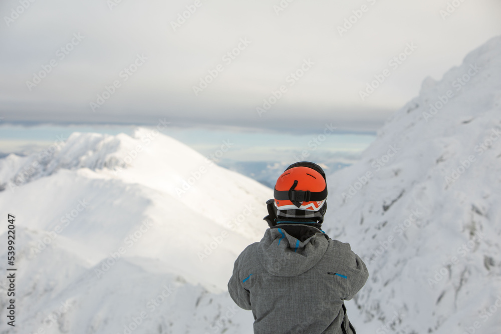 man skier enjoying landscape view of winter mountains