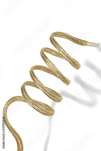 Cropped close-up shot of a pair of round gold shoelaces with plastic aglets. Curved lurex shoelaces are isolated on a white background. Front view.