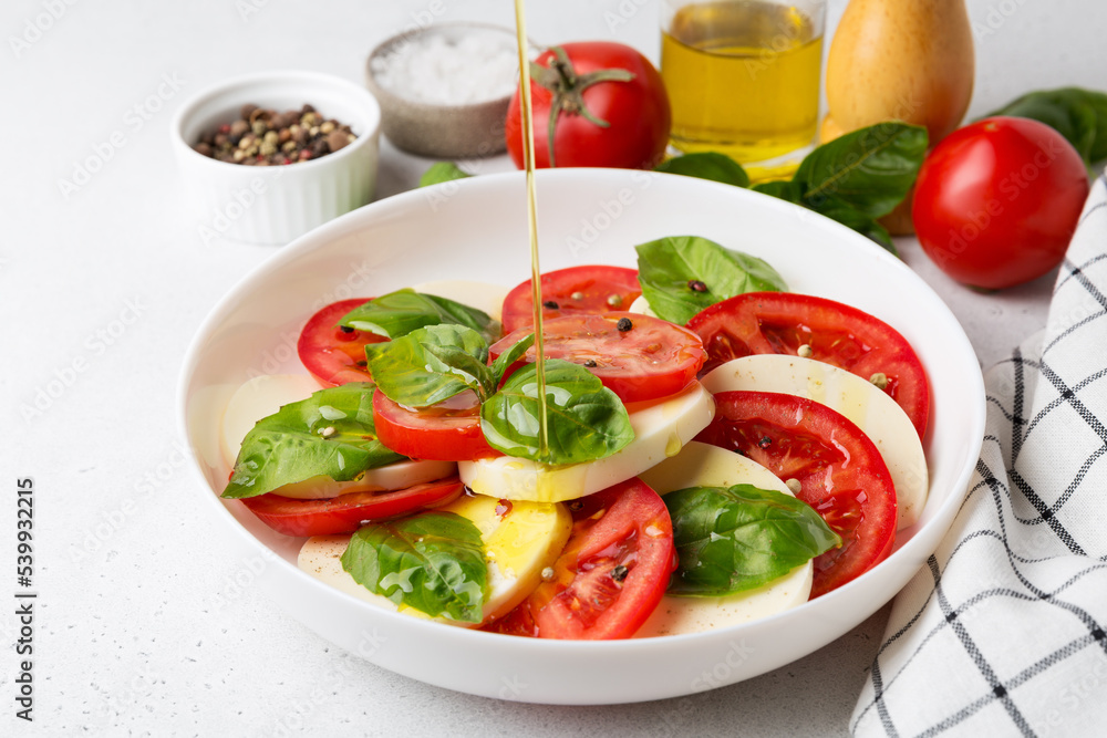 Caprese Salad with tomatoes and mozzarella with olive oil. Caprese Salad with tomatoes and mozzarella with olive oil.