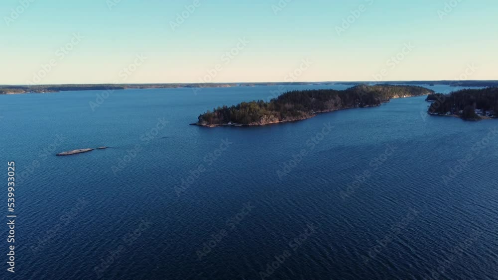 Blue wavy water and forested islands in Baltic sea, high static aerial