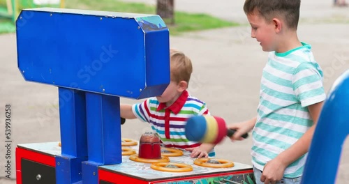 Children playing whack a mole arcade game at an amusement park. photo